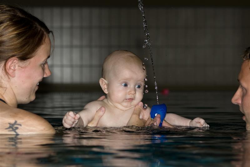 Baby blir rolig kjent med litt vannsprut før babysvømming