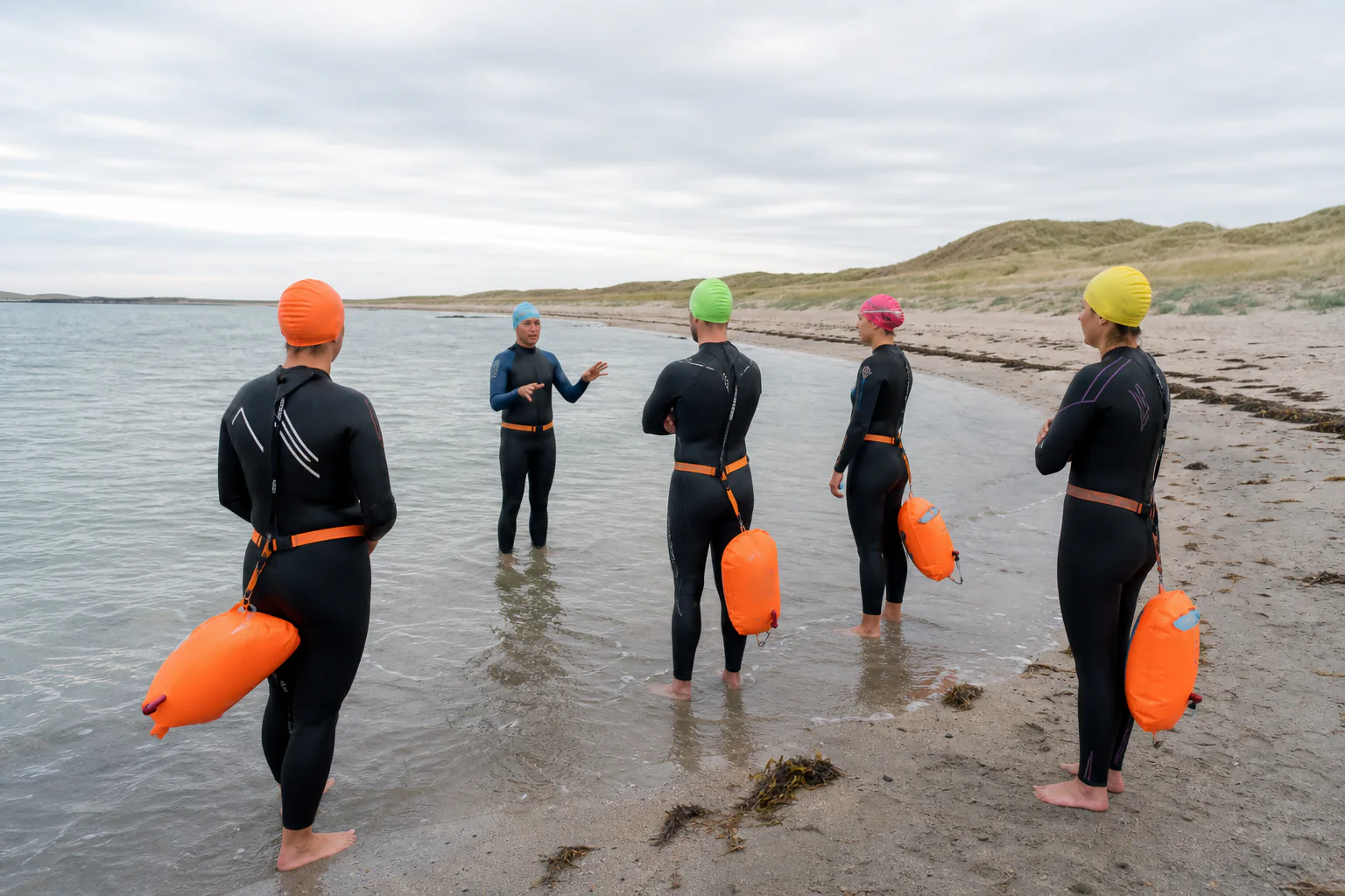Instruktør gir sikkerhetsinformasjon før utendørssvømming på strand på Jæren